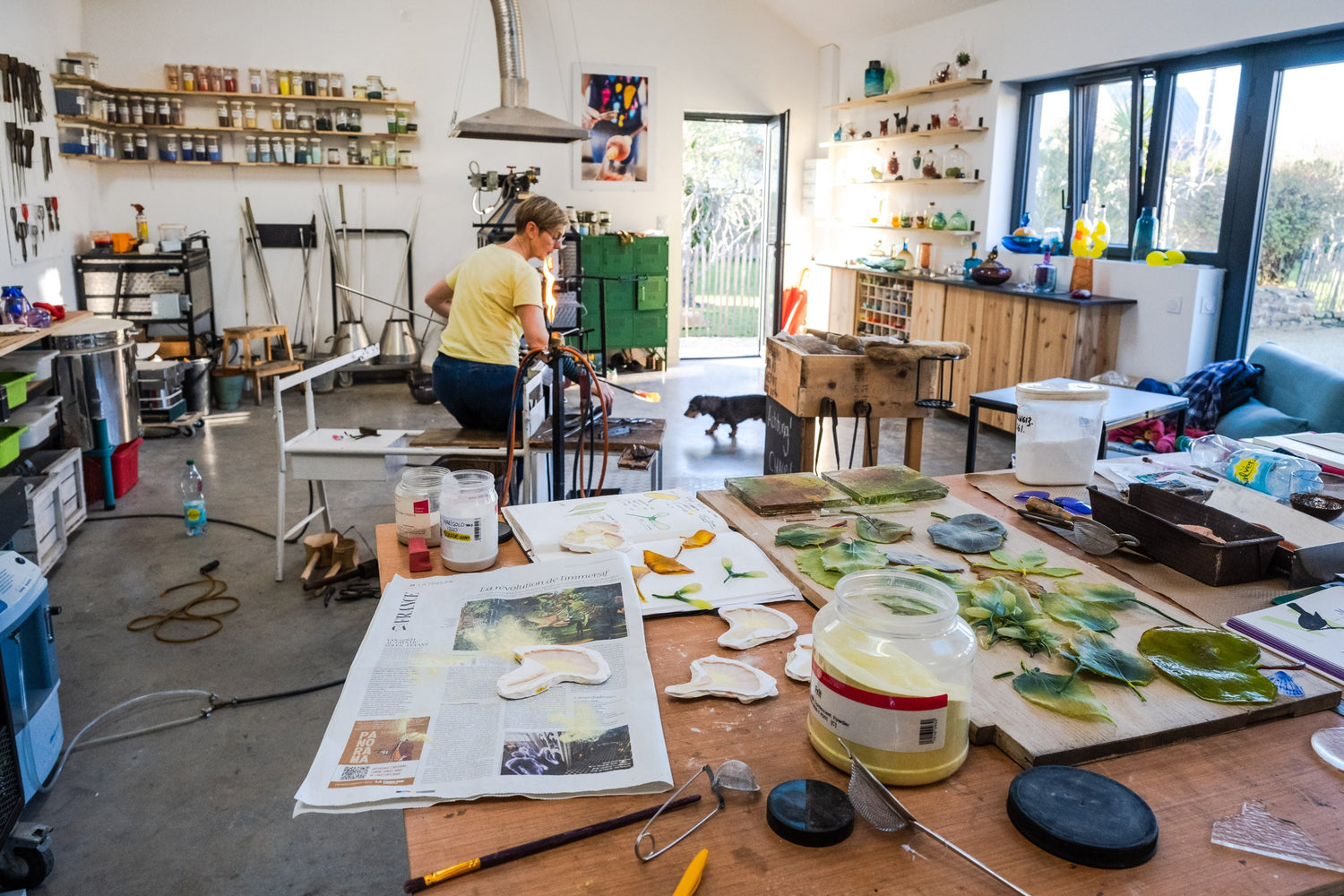 La souffleuse de verre dans son atelier travaille sur une création